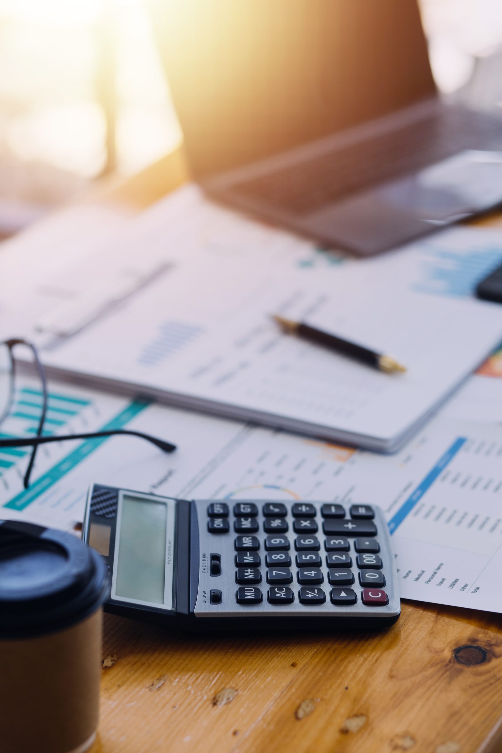 Close up of accountant working and analyzing financial reports project accounting with chart graph and calculator in modern office : finance and business concept.